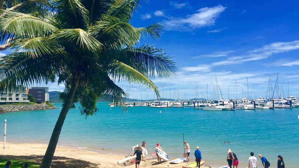 a group of people getting ready to try out SUP at airlie beach