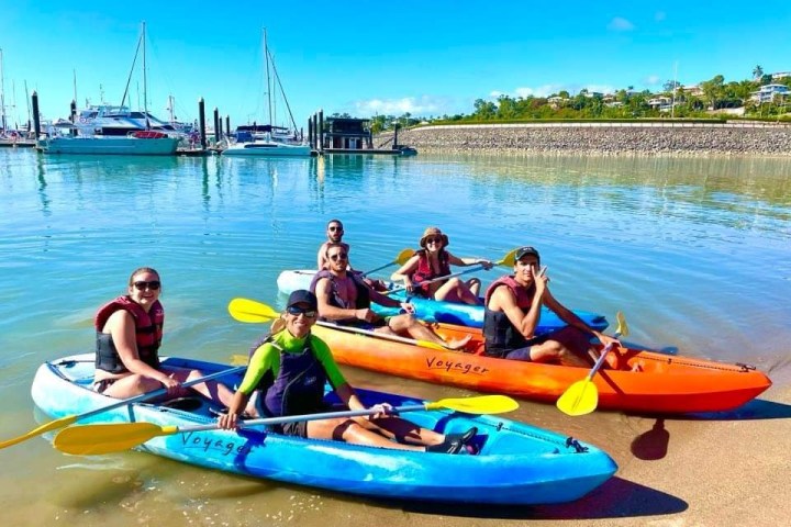 a group of people sitting in a boat on a body of water